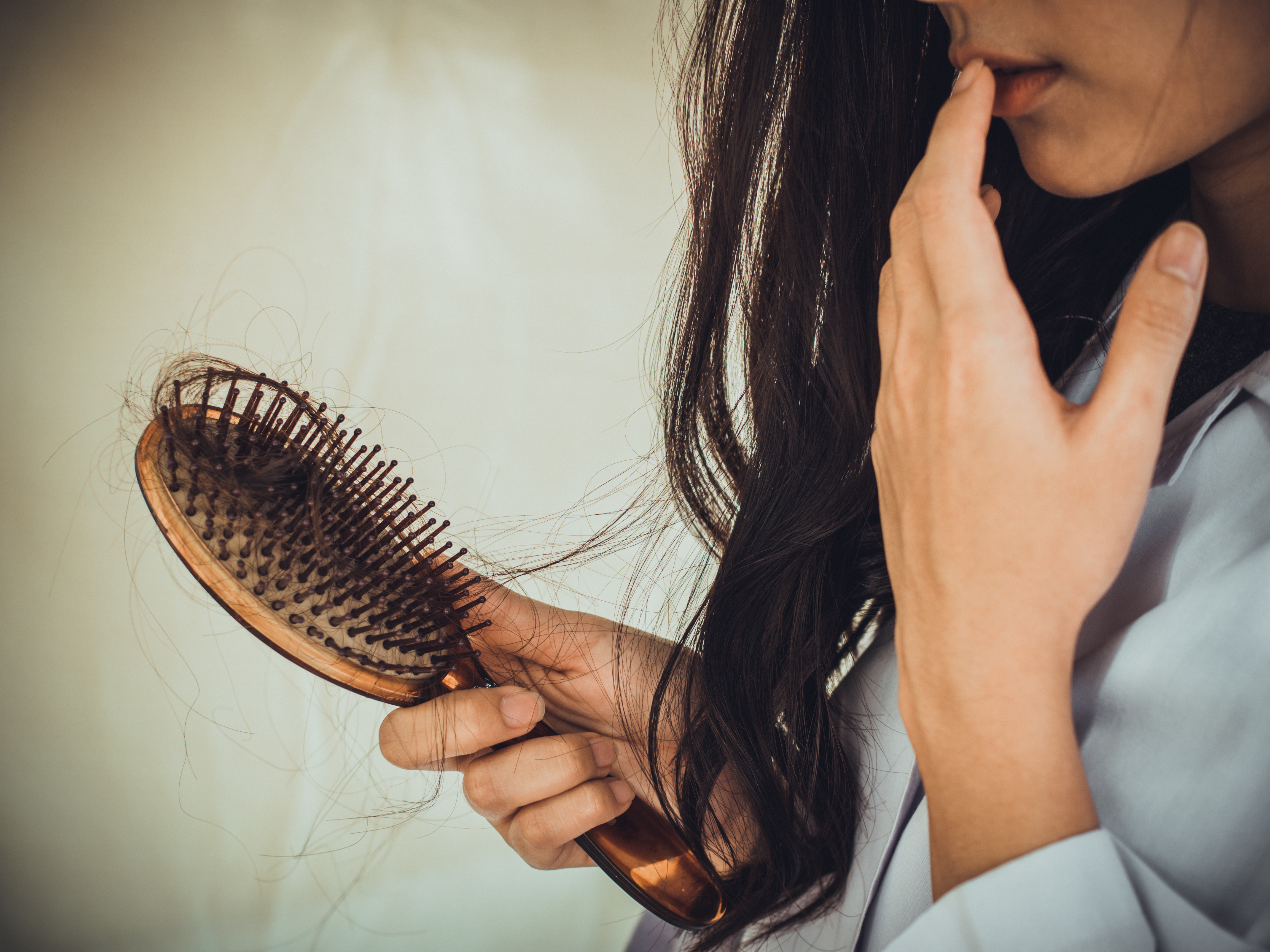 Woman brushing hair with hair loss