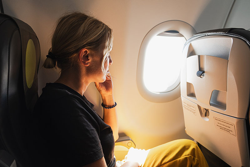 Woman sat by window on aeroplane